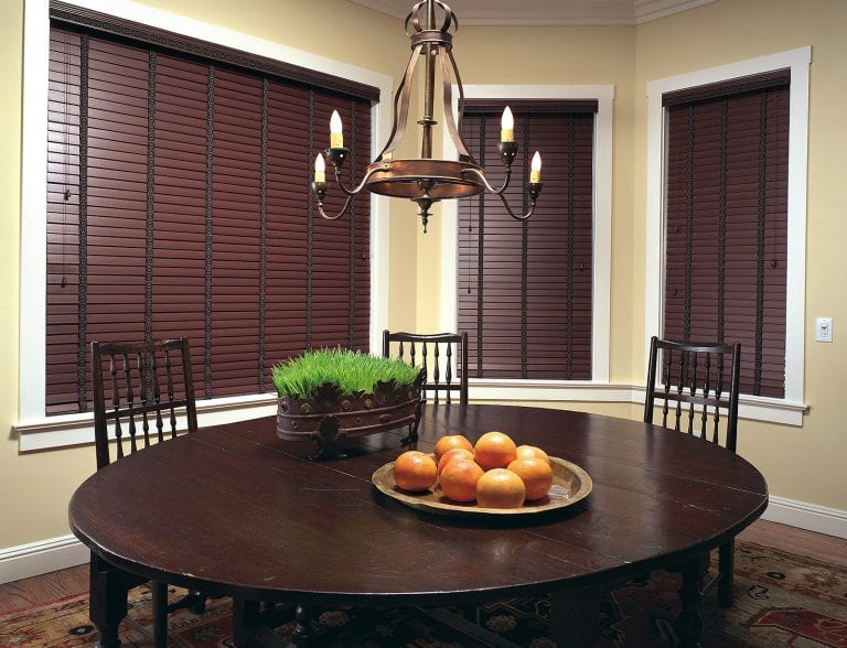 Brown blinds next to a dining room table.