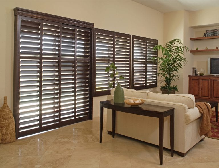 Dark stained shutters on sliding door and windows.