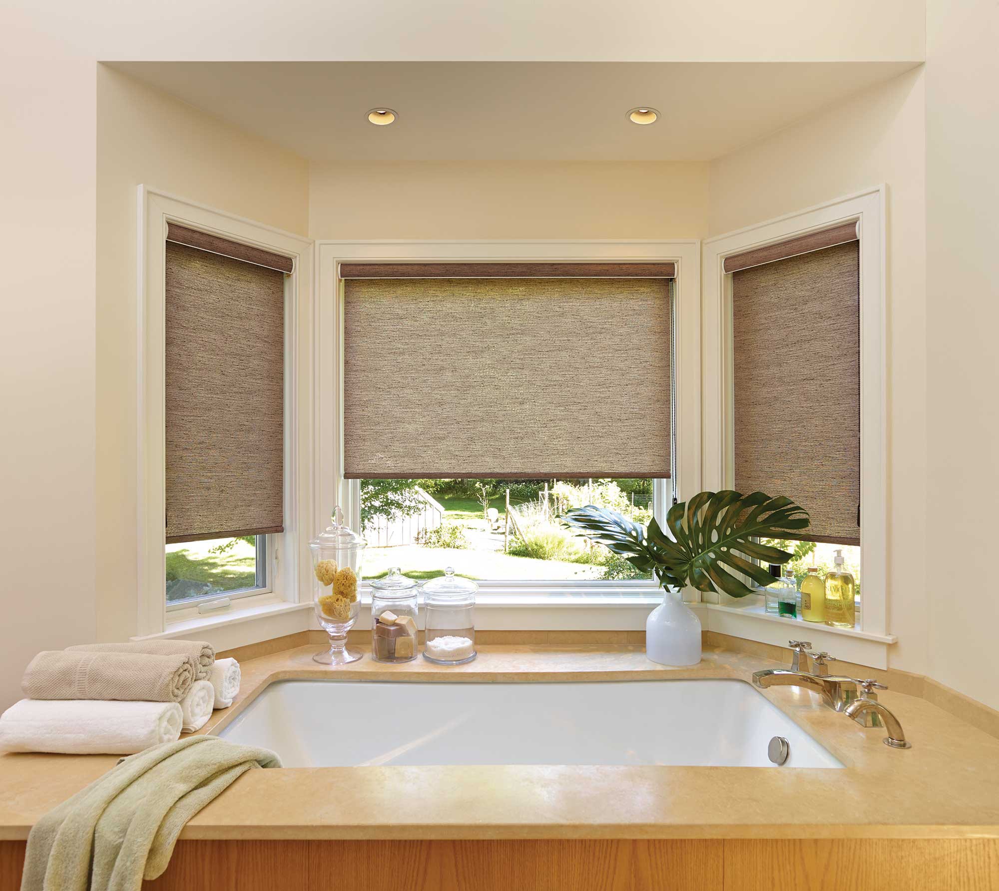 Privacy roller shades by a bath tub.