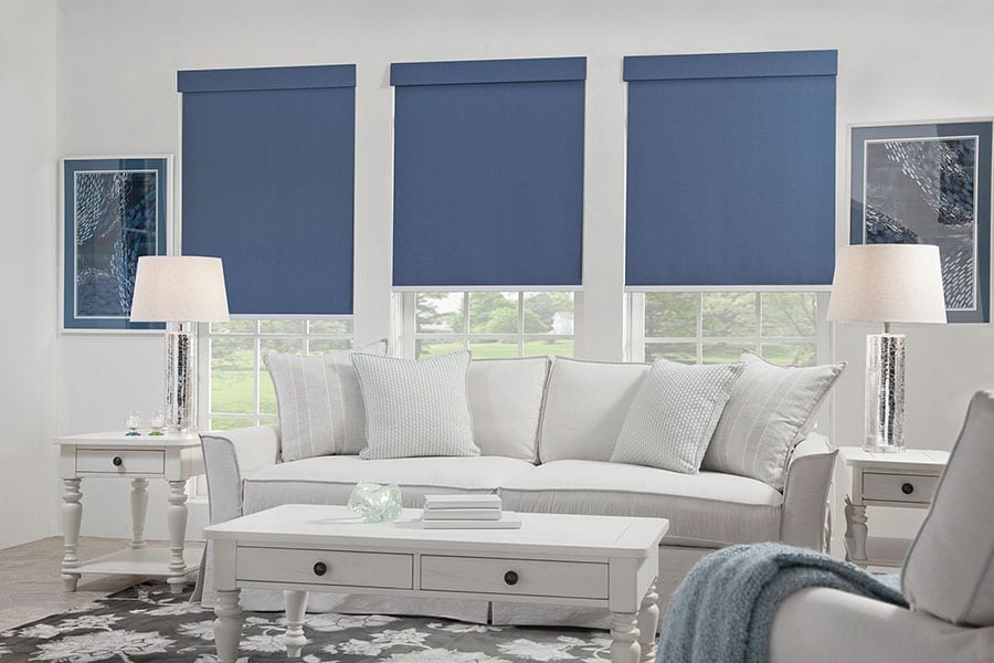 Blue roller shades in a white living area.