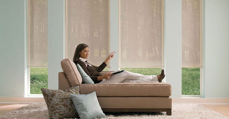 Motorized roller shades with a women operating the shades.