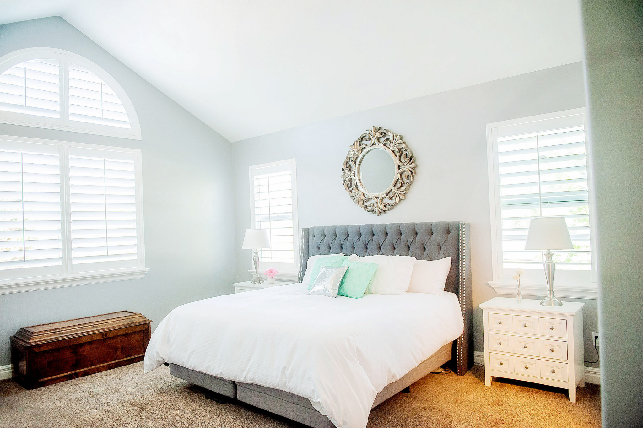 White Composite shutters with Tilt bar in a bedroom with an arched window
